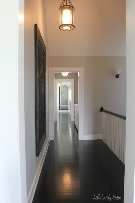 Black flooring, medium grey paint colors, and magnificent architecture in a second floor landing of an industrial farmhouse. #interiordesign #paintcolors #industrialfarmhouse #blackfloors Medium Grey Paint Colors, Industrial Farmhouse Interior Design, Industrial Farmhouse Interior, Farmhouse Interior Design Ideas, Grey Interior Paint, Black Flooring, Neutral Gray Paint, Moulding Ideas, Magnificent Architecture