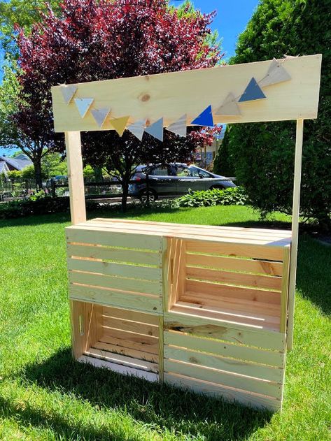 Use this easy to build crate stand for lemonade sales, farmer's market, or classroom dramatic play area. Homeroad.net #classroom #crates #lemonadestand #farmersmarket #dramaticplay #kids Wood Crate Lemonade Stand, Dramatic Play Market Stand, Build A Lemonade Stand Easy Diy, Build Your Own Lemonade Stand, Wooden Crate Lemonade Stand, Diy Store For Kids, Crate Stand Diy, Farmers Market Stand Diy, Wooden Lemonade Stand