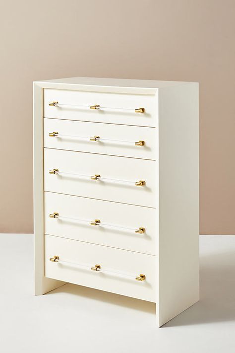 A harmonious pairing of gleaming brass and modern lucite accents punctuate the polished lacquer of our neatly proportioned Merriton collection. Featuring a streamlined, chamfered-edge silhouette, this dresser introduces refined glamour to any space. Better yet? Its elongated, narrow silhouette is perfect for smaller apartments or petite bedrooms that still desire ample wardrobe storage. For ordering assistance and more, please contact us. For aesthetic advice and tips to help decorate your space Narrow Chest Of Drawers, Narrow Dresser, Coral Bedroom, Three Drawer Dresser, Tall Dresser, White Dresser, Wardrobe Storage, Indoor Outdoor Pillows, White Home Decor