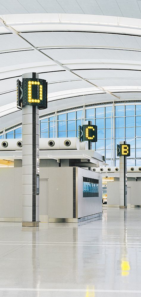 A new terminal at Toronto International Pearson Airport required a comprehensive wayfinding program to move passengers efficiently through the space.   The form of the building inspired the signage, which was designed to be a highly integral element of the architecture. Entro conducted extensive studies, including testing with visually impaired users, to ensure the graphics would be clearly visible from further distances. Airport Graphic Design, Airport Signage Design, Airport Wayfinding, Airport Signage, Signage Photography, Experiential Graphics, Airport Vibes, Toronto Pearson International Airport, Airport Signs