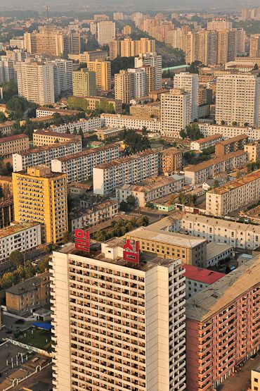 "Soon, a clean, tall city unfolded before us, and unfold is the word. Many cities unravel, their layouts like random bits of string flung in a box, but Pyongyang’s vistas and boulevards of sharp-sided buildings pan out so neatly, as definable sections on a vast plan of the city." North Korea: the Bradt Guide; www.bradtguides.com Clean City, Pyongyang North Korea, North Korea Photography, North Korean Architecture, South Korea North Korea, North Korea Map, Inside North Korea, Vertical City, Korea Language