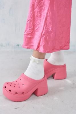 Stomp around in statement clogs by Crocs. The Siren is a bold update on the classic rubber clogs, complete with a platform sole, a curved silhouette and a stacked block heel. Features an open heel, a round toe and breathable holes for customising with your favourite Jibbitz. **Content + Care** \- 100% Rubber \- Spot clean | Crocs Pink Siren Heeled Clogs - Pink UK 6 at Urban Outfitters Taffy Pink Crocs Outfit, Clog Crocs Outfit, Pink Croc Fits, Crocs Pink Aesthetic, High Heel Crocs, Pink Platform Crocs, Pink Sparkly Crocs, Clean Crocs, Nicki Concert