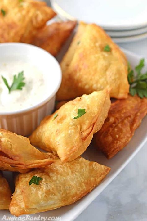 Samosas placed on a white table, farnished with parsely with a plate of yogurt dip in the middle. Samosa Recept, Meat Samosa, Beef Samosa, Easy Samosa Recipes, Chicken And Cheese, Samosa Recipe, Meat Appetizers, Party Appetizer, Starters Recipes