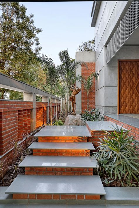 A three-level bungalow in Vadodara designed for a traditional Gujarati joint family | Architectural Digest India Bungalow Entrance Steps Design, Archdaily Interiors, Creative Ceiling Ideas, Entrance Stairs, Painted Brick Walls, Normal House, Brick Cladding, Concrete Ceiling, Pillar Design