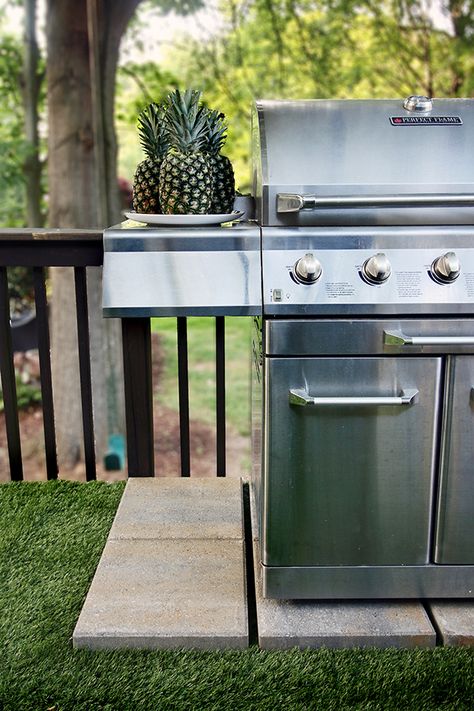 A gas grill sits atop some paver stones on an artificial grass deck floor Grill Storage Ideas Patio, Grill Platform Ideas, Grill Placement Outdoor, Pavers For Grill Area, Pavers Under Grill, Landscape Ideas For Grill Area, Paver Grill Station Diy, Grill On Pavers, Grill Pad Ideas