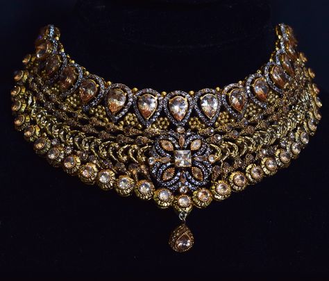 Introducing our exquisite bridal collar necklace, a true masterpiece that will make you feel like a queen on your special day. This stunning necklace is crafted with gold plating and features copper accents, adding a touch of warmth and elegance. Complete your bridal look with the matching jhoomar, earrings, and bindia that come with this set. The jhoomar adds a touch of traditional charm, while the earrings and bindia perfectly complement the intricate design of the necklace. Jhoomar Earrings, Gold Jeweled Bollywood Necklace, Bollywood Gold Jeweled Choker, Bollywood Style Gold Dual-tone Necklace, Collar Necklace Choker, Gold Dual-tone Bollywood Necklace, Gold Bollywood Multi-stone Necklace, Colored Necklace, Collar Choker