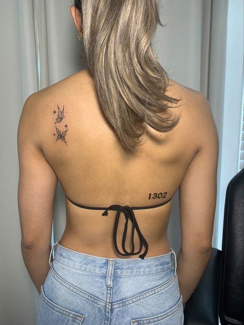 Young woman with back tattoos, wispy staggered butterfly back tattoo on upper left of back. Lower on the mid back a gothic font tattoo. Thin waist, bouncy ponytail. Upper Back Tattoo Women, Gothic Font Tattoo, Back Tattoo Women Upper, Women Tattoo Placement, Heart Locket Tattoo, Upper Back Tattoo, Locket Tattoos, Small Back Tattoos, Font Tattoo