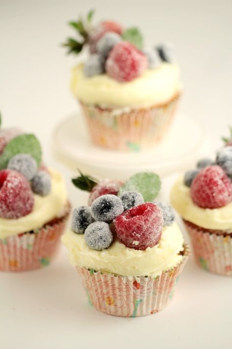 These Frosted Berry Cupcakes with an Orange Mascarpone Buttercream feature a fluffy orange cake topped with a luscious frosting, and sugared fruit. They are a beautiful cupcake full of bright flavours. Fruit On Cupcakes, Fresh Fruit Cupcakes, Cupcakes Decorated With Fruit, Fruit Topped Cupcakes, Cupcakes With Fruit On Top, Buttercream Desserts, Mascarpone Buttercream, Sugared Berries, Sugared Fruit