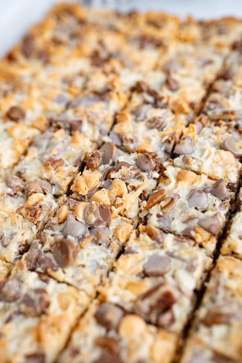 7 layer bars are a mixture of your favorite nuts, sweet chips, chewy coconut and caramel-y sweetened condensed milk. In short, they’re heaven in a bar! The classic 7 layers in a magic cookie bar are: a graham cracker crumb base, flaked coconut, semi-sweet chocolate chips, butterscotch chips, chopped pecans, vanilla & sweetened condensed milk. | best bar cookies | bar cookies recipes best | magic cookie bars | magic bars recipe | how to make magic bars | how to make magic cookie bars 7 Layer Cookie Bars, Recipes With Butterscotch Chips, 7 Layer Magic Bars, Bar Cookies Recipes, Coconut Flakes Recipe, Sweet Chips, Magic Bars Recipe, Magic Cookie Bar Recipe, 7 Layer Bars