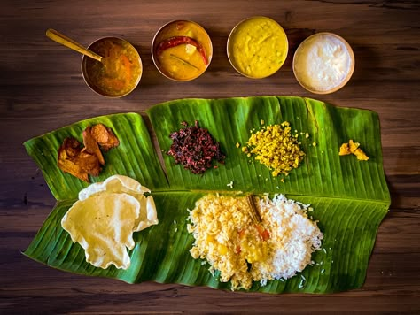 Sapad is South Indian meal. Served on a banana leaf, the banana leaf is laid so that the leaf tip is pointed left. Before anything is served you have to sprinkle water and clean it. The top half of the banana leaf is reserved for accessories dishes and the lower half for the rice. Accessories: fried chips, aplam, poriyal, chutney Server serves, yellow daal(lachka), then rassam, then sambar, then curd.  P.S: If it is not served as per rule my husband gets annoyed. And in picture I served with one Banana Leaf Rice, Banana Leaf Plates, South Indian Thali, Indian Food Photography, Recipes Using Bananas, Indian Meal, Recipe Banana, Malaysian Cuisine, Dominican Food