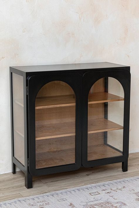 Featuring a playful double arch design, this contemporary wooden cabinet is versatile enough for any space. The two door design opens to a trio of interior shelves that can be styled with dishware, decor, or be used as a bar cart or other storage. Pair with the Easton Cane Coffee Table to truly elevate your space. Modern arch design 3 shelf storage Adjustable shelving Two door cabinet Acacia + oak wood Fully assembled Wooden feet Not sold as a set Two Door Design, Cane Coffee Table, Modern China Cabinet, Arch Cabinet, Two Door Cabinet, Desert Boho, Entryway Cabinet, Interior Shelves, Wooden Cabinet