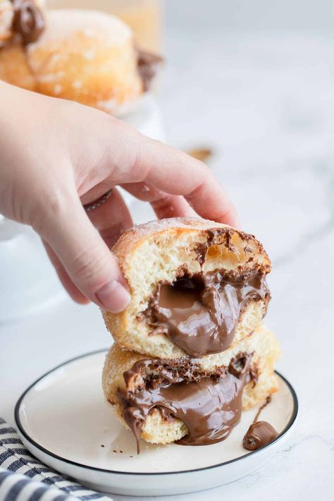 two nutella doughnuts on a small plate with nutella coming out of the donuts and a hand holding the donuts. Nutella Mousse, Nutella Recipes Easy, Popular Desserts, Hazelnut Spread, Dessert Pictures, Small Plate, Gluten Free Cooking, Donut Recipes, Hand Holding