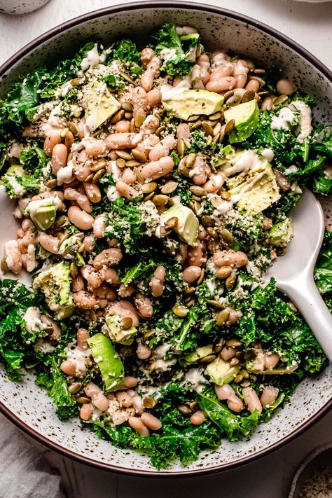 This copycat Erewhon Kale White Bean Salad tosses kale, avocado, cannellini beans, and seeds in a lemony tahini dressing. A must-try healthy lunch, light dinner, and satisfying side dish! Whole Foods Kale Salad Recipe, Kale And Avocado Salad, No Dairy Salad, Kale And Beans Recipe, Erewhon Kale Salad, High Protein Kale Salad, Kale White Bean Salad, Kalettes Salad, Creamy Salad Recipes