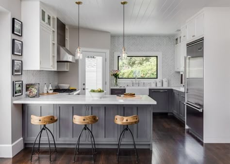 Soft warm gray walls are paired with cool gray base cabinets and a gray-and-white marble backsplash for a fresh take on neutrals. Distressed Kitchen Cabinets, Distressed Cabinets, Distressed Kitchen, Kitchen Peninsula, Серая Кухня, Gray And White Kitchen, Kitchen Cabinets Makeover, Grey Kitchen Cabinets, Grey Kitchens