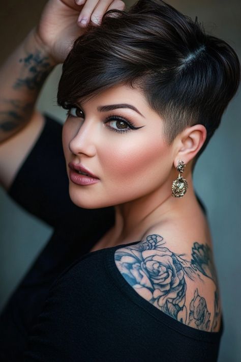 Woman with short hair and floral shoulder tattoo, wearing large earrings, looking confidently at the camera. "bixie" Haircut Round Face, Latina Pixie Haircut, Pixie For Round Faces Plus Size, Short Hair Cuts For Women Pixie Undercut, Short Hair Styles For Chubby Faces, Pixie Cut Round Face Plus Size, Chubby Face Short Hair, Short Haircuts For Plus Size Women, Short Sassy Hair Over 50