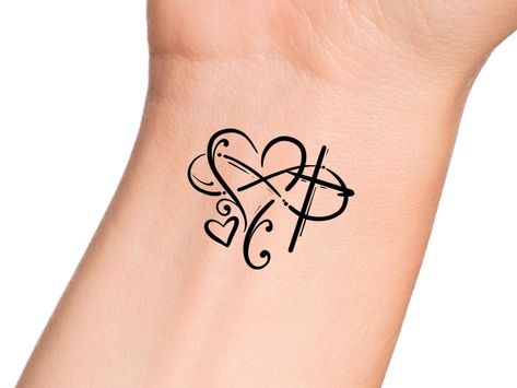 Cross Heart Infinity Temporary Tattoo - Religious Tattoo Size: The size of this Temporary Tattoo is approximately 1 1/2 inches in length. If you would like this design in a smaller or larger size that isn't already listed, please message us directly on Etsy BEFORE placing your order so we can provide you with accurate pricing. Directions: 1. Peel off the clear plastic layer with your fingernail or a pair of tweezers. Hold the temporary tattoo design side up in your hand and with your other hand run your thumb along the side of the tattoo slightly upward to lift the plastic layer. You will see the plastic layer naturally lift up when your thumb runs across the side. 2. Cut excess paper around tattoo with scissors to eliminate any unnecessary adhesive on your skin after applying. 3. Apply th Infinity Tattoo With Cross, Infinity Wrist Tattoos For Women, Pretty Cross Tattoos For Women, Cross And Butterfly Tattoo, Love Infinity Tattoo, Heart Cross Tattoo, Cross Wrist Tattoos, Cross Heart Tattoos, Pretty Cross Tattoo