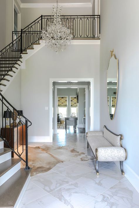 A low-backed settee lends an aura of elegance to this foyer Entrance Lobby Design Apartment, Wall Decor Foyer, Entrance Lobby Design, Foyer Wall Decor, Entrance Foyer Design, Hallway Seating, Foyer Wall, Apartment Entrance, Statement Chandelier