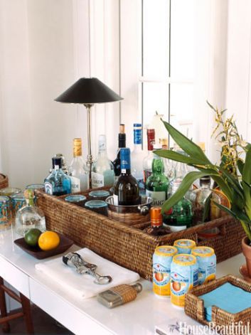 Organized BarDesigner Tom Scheerer corralled barware and liquor bottles in a basket with matching napkin caddy in a Vero Beach, Florida house: "I put it between the living and family rooms. Bars express welcome and conviviality, and I like them out in the open." Photo: Matthew Hranek Bar Deco, Bandeja Bar, Beach Basket, Home Bar Design, Bar Tray, Bar Cart Styling, Beautiful Bars, Bar Cart Decor, Bar Set Up