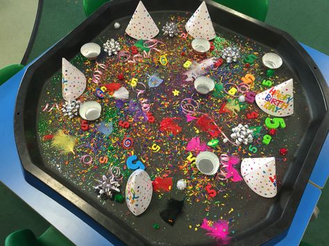 Birthday tuff spot. Includes a party hat for each child, glitter, star sequins, number 5's, cup cake cases, candles, coloured wood chip, spinning tops, Pom Poms, feathers and birthday ribbons! #tuffspot #tufftray Birthday Party Eyfs Activities, Eyfs Birthday Activities, Birthday Eyfs Activities, Birthday Topic Eyfs, Tuff Tray Party Ideas, Birthday Tuff Tray Ideas, Messy Play Party, Birthdays Eyfs, Birthday Tuff Tray