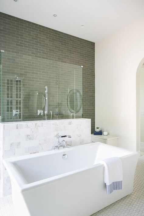 A rectangular freestanding bathtub sits in front of a marble and glass shower accented with gray staggered wall tiles and fitted with two polished nickel shower kits. Bath In Front Of Shower Wall, Free Standing Tub With Ledge, 2 Person Freestanding Bathtub, Freestanding Tub With Ledge Behind, Rectangle Bathtub, Free Standing Bath Tub Marble Wall, Industrial Cottage, Freestanding Rectangular Bathtub, Edwardian Bathroom