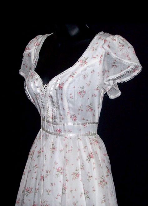 This is a vintage Gunne Sax dress from the 70s. It's made from a cotton blend material with pink roses and a white background. Its trimmed with lace, ribbon, and pearls. The inside is lined. The front laces up like a corset. The corset can be loosened slightly to add a little more room if needed. The bottom has a full skirt with an attached slip underneath. It zips and ties in the back. CONDITION: Great condition, no flaws found. New with tag. ESTIMATED SIZE: XS. The size tag is marked as a 7 in Short Gunne Sax Dress, Floral Coquette Dress, Gunne Sax Prom Dress, Prarie Dresses 70s, Pink And White Outfit Ideas, Gunne Sax Dress Vintage 70s, Cottagecore Closet, Cotton Wedding Dress, Southern Dress