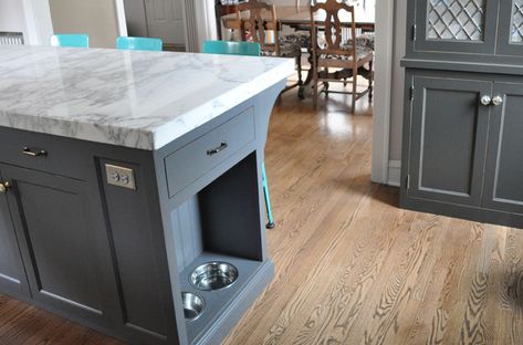 Stylish and thoughtful kitchen design charcoal gray kitchen cabinets with nickel hardware, and Lyon Stool with Steel Back in turquoise blue paired with a gray kitchen island with carrara marble countertops and built in pet food bowls. Pet Food Cabinet, Charcoal Gray Kitchen Cabinets, Island Storage, Kitchen Island Storage, Grey Kitchen Island, Серая Кухня, White Kitchen Island, Dog Food Bowls, Grey Kitchen Cabinets