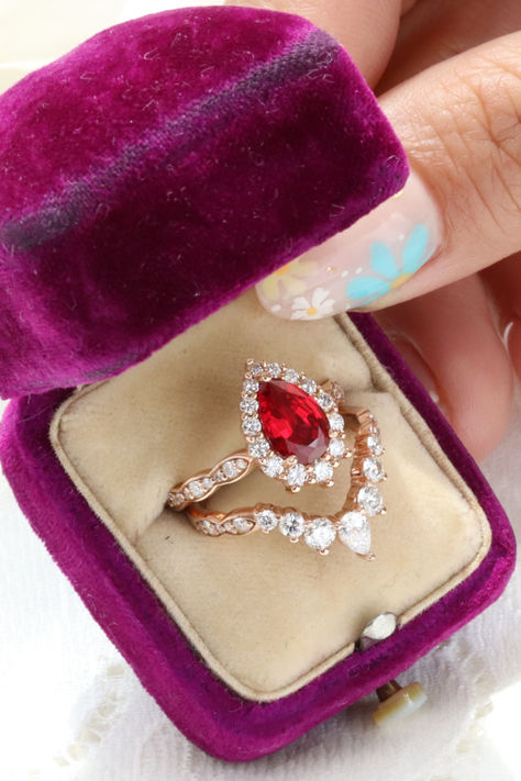 This breathtakingly unique ruby bridal ring set showcases a large halo diamond ruby engagement ring with a deluxe large diamond wedding ring in matching scalloped diamond wedding band as a stunning stackable ruby ring set! Check out more of our Ruby Bridal Ring Set by La More Design! 
#uniqueengagementring #alternativeengagementring #stackablerings Unique Bridal Sets, Diamond Ring Stack, Wedding Rings Gold, Ruby Ring Set, Vintage Style Wedding Rings, Engagement And Wedding Rings, Diamond Stacking Rings, Ruby Engagement Ring, Rings Gold