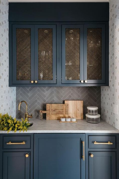 Gorgeous blue wet bar cabinets are accented with brass hardware and a honed marble countertop holding a small sink beneath a brass gooseneck faucet. Wet Bar Cabinets, Navy Kitchen Cabinets, New England Style Homes, Spanish Style Kitchen, Kate Marker Interiors, Beautiful Backsplash, Navy Kitchen, Herringbone Tile, Blue Cabinets