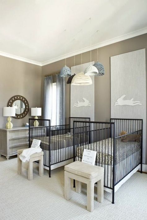 Adorable twin nursery with cluster of crocheted pendants over his and her twin nursery cribs filled with brown and yellow crib bedding and cream ottomans at foot off cribs. Chic nursery features bunny art on vertical gray panels over black modern cribs as well as round mirror over gray curved dresser with yellow table lamp on gray walls accented with blue drapes. Twin Baby Rooms, Twins Nursery, Shared Nursery, Twin Nursery, Contemporary Nursery, Crochet Lamp, Nursery Rooms, Baby Twins, Adorable Nursery