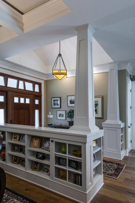 This creative storage space was designed by TriplePoint Design Build to accommodate books and living room knickknacks in the entryway of this remodeled home. The bookcases and columns, which were painted white to match to ceiling and trim of the home, divide the foyer from the living room. The size of the cubby space mirrors the sidelight cutouts above the front door for an interesting effect. Stunning Entryways, Craftsman Interior, Half Walls, Craftsman Bungalow, Craftsman Style Home, Cape Cod House, Craftsman Style Homes, Craftsman Bungalows, Craftsmen Homes