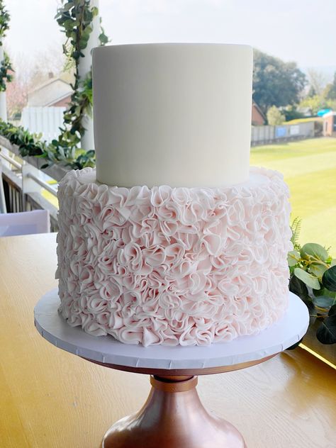 A 2 tier wedding cake displayed on a rose gold cake stand. The bottom tier has pale pink ruffles all over and the top tier is plain white. Pink And White 2 Tier Birthday Cake, Pink And White Wedding Cake 2 Tier, Two Tier Cake Designs, White And Pink Cake, Plain White Cake, Buttercream Ruffle Cake, 2 Tier Wedding Cake, Cake Design Wedding, 30th Ideas