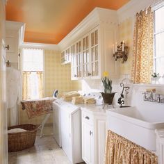 Quaint cottage accessories burst with color in this small galley laundry room. An oversized farmhouse sink is great for utility and helps add some character to the space. Cottage Accessories, Yellow Laundry, Cottage Laundry Room, Yellow Laundry Rooms, Laundry Room Paint Color, Tudor Kitchen, Laundry Room Paint, Traditional Laundry Room, Laundry Room Decorating