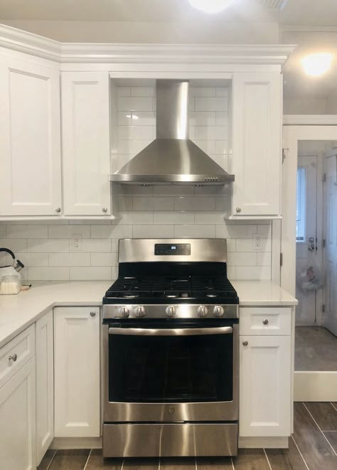 Adorable white kitchen with stainless steel hood Stainless Steel Oven Hood, Kitchen With Metal Range Hood, Metal Kitchen Hood Ideas, Oven Exhaust Hood, Kitchen Hood Ideas Stainless Steel, Kitchen Stove Vents Oven Hood, Range Hood Ideas 2023, Kitchen Range Hood Ideas Stainless Steel, Hood Vents Kitchen Stainless Steel