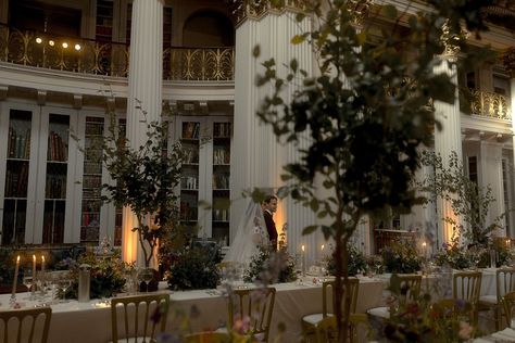 The bride and groom walk around their wedding breakfast at the Edinburgh wedding venue, Signet Library decorated with tall tree table centrepieces and purple wedding flowers for classic and traditional wedding Wedding Venue Library, Wedding Venues Library, Botanical Library, Bookstore Wedding, Edinburgh Wedding Venues, Enchanted Library, Library Inspiration, Edinburgh Wedding, Library Wedding