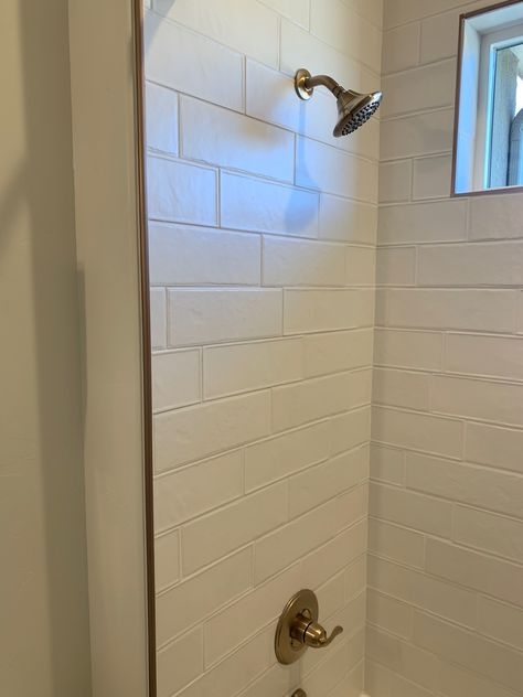 Metal trim around tiled shower. White tiles + gold trim? Tile Shower Edge Trim, Metal Tile Trim, White Schluter Tile Edge, Lake House Master, Gold Tile, Tile Edge, Metal Tile, Bathroom Shower Tile, Basement Bathroom