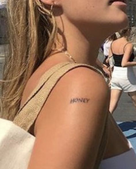 “HONEY” shoulder tattoo Word Tattoo Shoulder, Shoulder Tattoos Quotes, Words On Shoulder Tattoo, Shoulder Stick And Poke, Shoulder Text Tattoo, Honey Stick Tattoo, One Word Tattoos Placement, Honey Word Tattoo, Shoulder Word Tattoo