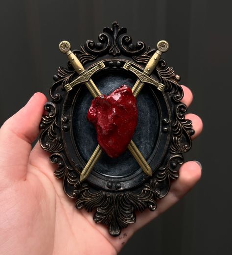 AVAILABLE: Preserved Chicken Heart with “Piercing” Bronze Swords. A bit stressful making this piece but I love how it turned out 😍🫀 . . . #smallbusiness #artist #art #goth #gothic #taxidermy #oddity #odd #curiosity #curios #curio #curiosities #gothart #gothicart #decor #gothicdecor #gothaesthetic #aesthetic #wunderkammer #cabinetofcuriosities #bronze #frame #resin #resinart #artwork #gothdecor #preserved #odditiesandcuriosities #heart #preservation Resin Gothic Art, Gothic Taxidermy, Eurasian Magpie, Oddities And Curiosities, Purple Emperor, Seashell Frame, Chicken Heart, Fossilized Coral, Bronze Frame