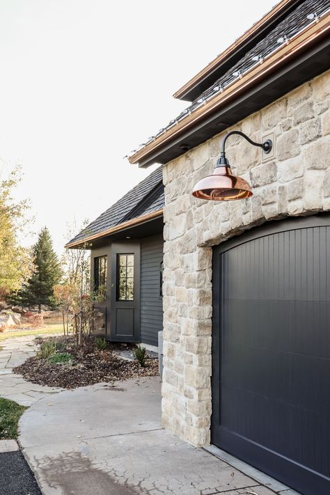 Modern home exterior with black garage doors and stone Renovation Facade, Designer Doors, Front Porch Lighting, Exterior Renovation, Exterior Makeover, Casa Exterior, Modern Farmhouse Exterior, Exterior Remodel, Black House Exterior