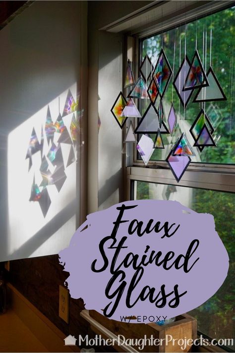 This Sun Catcher was inspired by a pin! We recreated a stained glass art piece using chipboard shapes, epoxy, alcohol inks, and mica powder. The shapes were cut on a Cricut Maker, filled with epoxy and the fronts and backs covered with black vinyl. The black vinyl gives the illusion of leaded stained glass. Place the mobile in a window to catch the sun or breeze. #diy #homedecor #falldecor Epoxy Stained Glass Window, Epoxy Window Art, Stained Glass Cricut, Cricut Stained Glass Window, Stained Glass Mobile, Diy Stained Glass Projects, Fake Stained Glass Diy, Faux Stained Glass Diy, Stained Glass Kits