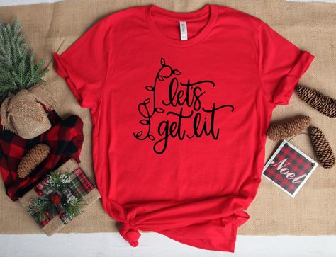 Christmas T-Shirt | Let's get lit | Funny Christmas Tee All of our items are handmade with love💜 Our shirts are made using commercial grade, high quality, Heat Transfer Vinyl. They are pressed with a profession heat press machine to ensure durability of the print. This process gives a long lasting finish to all of our designs. Women: For a woman’s fit, we recommend to go down a size. For a looser fit, stick with your normal size. Men: Stick with your normal size. Returns and Exchanges Policy Ea Family Christmas Outfits, Grafic Tees, Winter Things, Funny Kids Shirts, Lets Get Lit, Christmas Tee Shirts, Creative Shirts, Matching Sweaters, Christmas Things