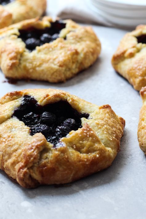 Blueberry Galettes are a delicious summer treat. They're made with a blueberry filling that has a hint of lemon and a cornmeal crust that is folded over for a rustic dessert. Serve this as a breakfast pastry or an afternoon treat with a scoop of vanilla ice cream. #blueberrygalette #cornmealcrust #thesweetoccasion Cornmeal Crust, Blueberry Galette, Chocolate Hazelnut Cookies, Blueberry Filling, Completely Delicious, Rustic Dessert, Sanding Sugar, Hazelnut Cookies, Breakfast Pastries