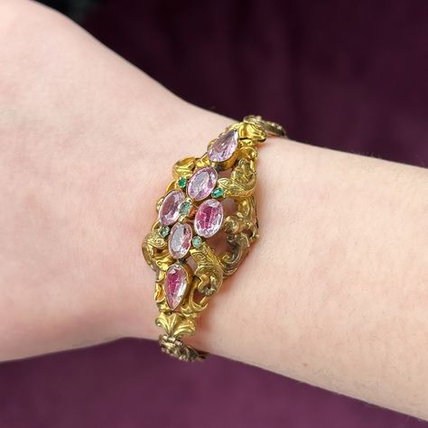 New in! A lavish antique Victorian bracelet beautifully preserved from the mid-19th Century. It displays a sumptuous domed gallery in the centre consisting of elaborate foliate metalwork and detailed engraving with six foil-backed pink topaz and five green emeralds crowned on top. The piece is fashioned entirely in 18ct gold and is fitted with a fabulous articulated band made up of scrolled links and a box clasp. It’s a remarkable antique bracelet and is even accompanied by its original fit... Victorian Bracelet, Edwardian Engagement Ring, Emerald Bracelet, Antique Bracelets, Pink Topaz, Box Clasp, Fiery Red, Memento Mori, Antique Jewellery