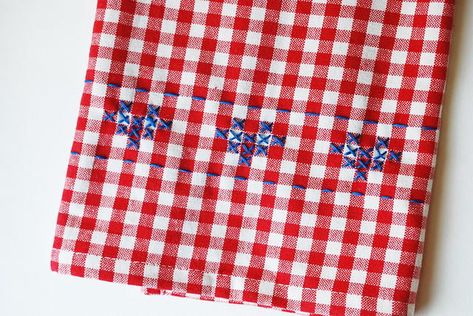 Try this easy cross stitch technique on all your gingham dish towels! This easy embroidery project has style and function, and the easy to follow tutorial has lots of room for you to get creative. Follow the pattern for a cross stitched heart dish towel or create a design of your own! You can use any color embroidery floss on any gingham material for the same simple and classic "chicken scratch" embroidery effect. This cross stitch towel DIY is fast and fun. You'll love your newly embroidered to Hand Towel Cross Stitch Patterns, Gridding Cross Stitch Fabric, Cross Stitch On Gingham, Gingham Cross Stitch, Gingham Needlepoint Stitch, Gingham Kitchen Towel, Gingham Embroidery, Ornament Designs, Chicken Scratch Embroidery