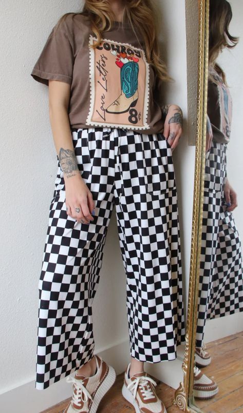 Our mid-rise Checkmate Pants are here to take trousers to another level. With a comfy elastic waistband and a wide-leg fit, they'll have you looking stylish and feeling cozy! Perfect for a casual day out, the washed black and white checkered print creates a bold and stylish look. Go ahead, make your move! These run very generous. I always wear an 8/10 or a large and I wear a medium in these comfortably. Size down please. Mid-rise waist Pockets Comfy elastic waistband Wide leg fit Washed black an Outfits With Checked Pants, Comfortable Punk Outfits, Reggae Outfit Ideas, Mid Size Eclectic Fashion, Pattern Trousers Outfit, Linen Pants Plus Size Outfits, Black Gingham Pants Outfit, Comfortable Outfit, Adronymous Outfits