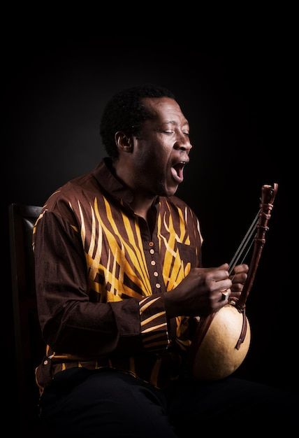 African black man with ethnic musical in... | Premium Photo #Freepik #photo #music-man #music-artist #musician #play-guitar Photo Music, Play Guitar, Music Man, Music Artist, Black Man, Musical Instrument, Premium Photo, Musical Instruments, Black Men