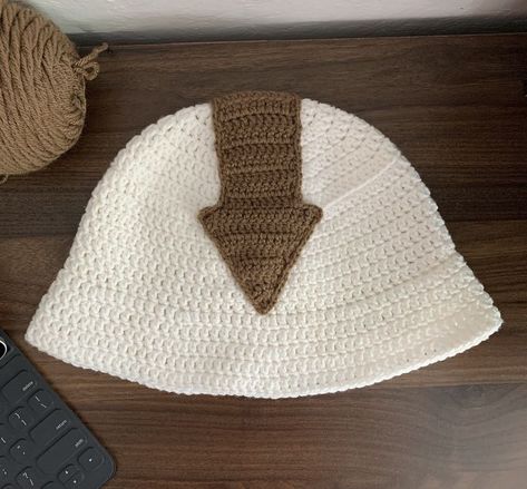 Link to the crochet bucket hat tutorial: https://youtu.be/ps7lSAG1nIg Helloo! Today's tutorial is a continuation of the last one where we crocheted a bucket hat. This video goes through how to crochet and sew on an arrow to a bucket hat to make the Appa bucket hat! This hat is based on Appa, Avatar Aang's flying bison in the amazing tv show Avatar: The Last Airbender. Avatar The Last Airbender Crochet Patterns Free, Appa Bucket Hat Crochet, Knitting Bucket Hat, Atla Appa, Appa Bucket Hat, Appa Hat, Avatar The Last Airbender Appa, Crochet Bucket, Crochet Hats Free Pattern