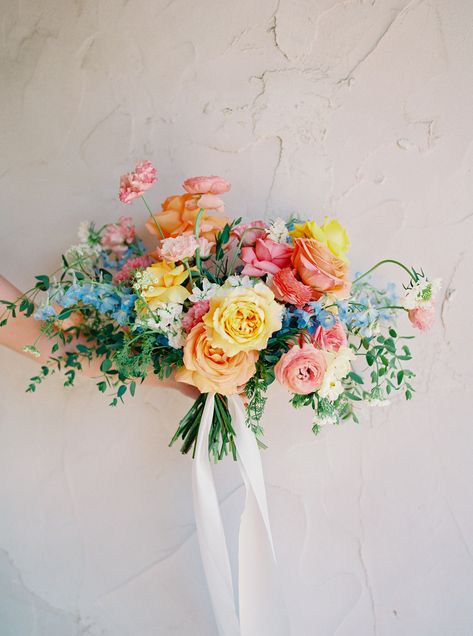 Photos by Stephanie Michelle Photography Peri & Nicholas’ summer wedding took place at Villa Antonia— just outside of Austin, Texas. Their pastel flowers featured a rainbow of colors: shades of pink, pops of yellow, notes of blue and warm touches of coral. Peri’s bridal bouquet was a brilliant arrangement of vibrant blooms that felt elegant but whimsical. Rainbow Bouquet, Wildflower Wedding Theme, Flowers Poppy, Colorful Bridal Bouquet, Small Wedding Bouquets, Bridal Bouquet Summer, Bridal Bouquet Spring, Bridal Bouquet Blue, Pastel Wedding Flowers