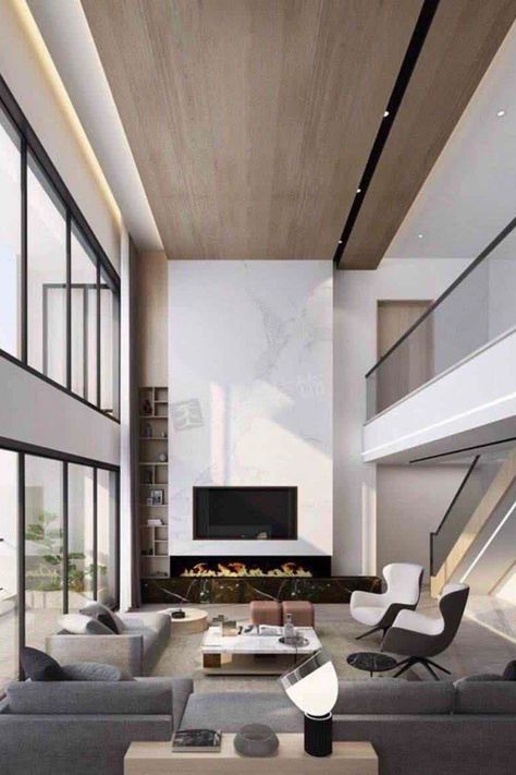 We're obsessed with this living room design. It has unique details and the perfect statement pieces! Find out the Best Interior Designers in New York City in the link below! #newyorkfurniture #newyorkart #newyorkarchitecture #newyorkproperty #newyorkdesigner Double Height Fireplace Modern, Double Volume Living, High Ceiling Tv Wall Interior Design, Wood Accent Wall High Ceiling, Modern Fireplace High Ceiling, Double Height Living Room Fireplace, Double Volume Ceiling Design, Tv Wall Double Height, Fireplace Double Height