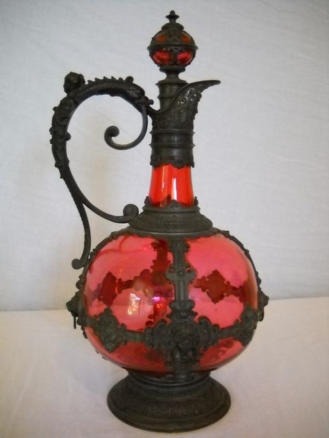 Antique decanter of ruby red glass set in intricate metalwork (1700's-1800's). I love this! Gothic Vase, Hourglasses, Cranberry Glass, Antique Bottles, Gothic Decor, Gothic Home Decor, Gothic House, Bottles And Jars, Decanters