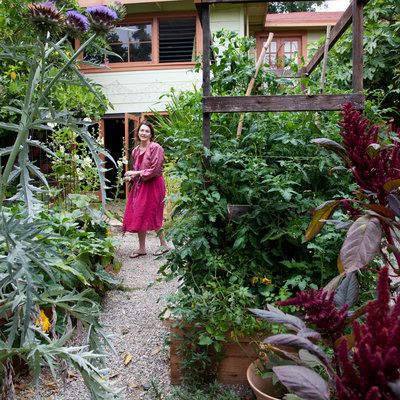 Brimming with planter beds from front to back, this yard blooms with amaranth and artichokes in the foreground, adding color to a veggie-friendly scene. Low Water Landscaping Front Yard, Edible Garden Ideas, Long Planter, Drought Tolerant Perennials, Planter Beds, Garden Paving, Sunset Magazine, Leafy Plants, Edible Landscaping